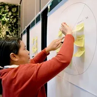 A designer mapping a user journey with sticky notes on a whiteboard